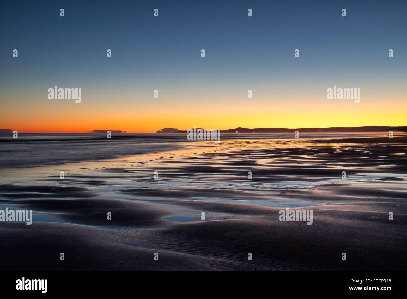 Winter dawn over East Beach at low tide. Lossiemouth, Morayshire, Scotland. Long Exposure Stock Photo