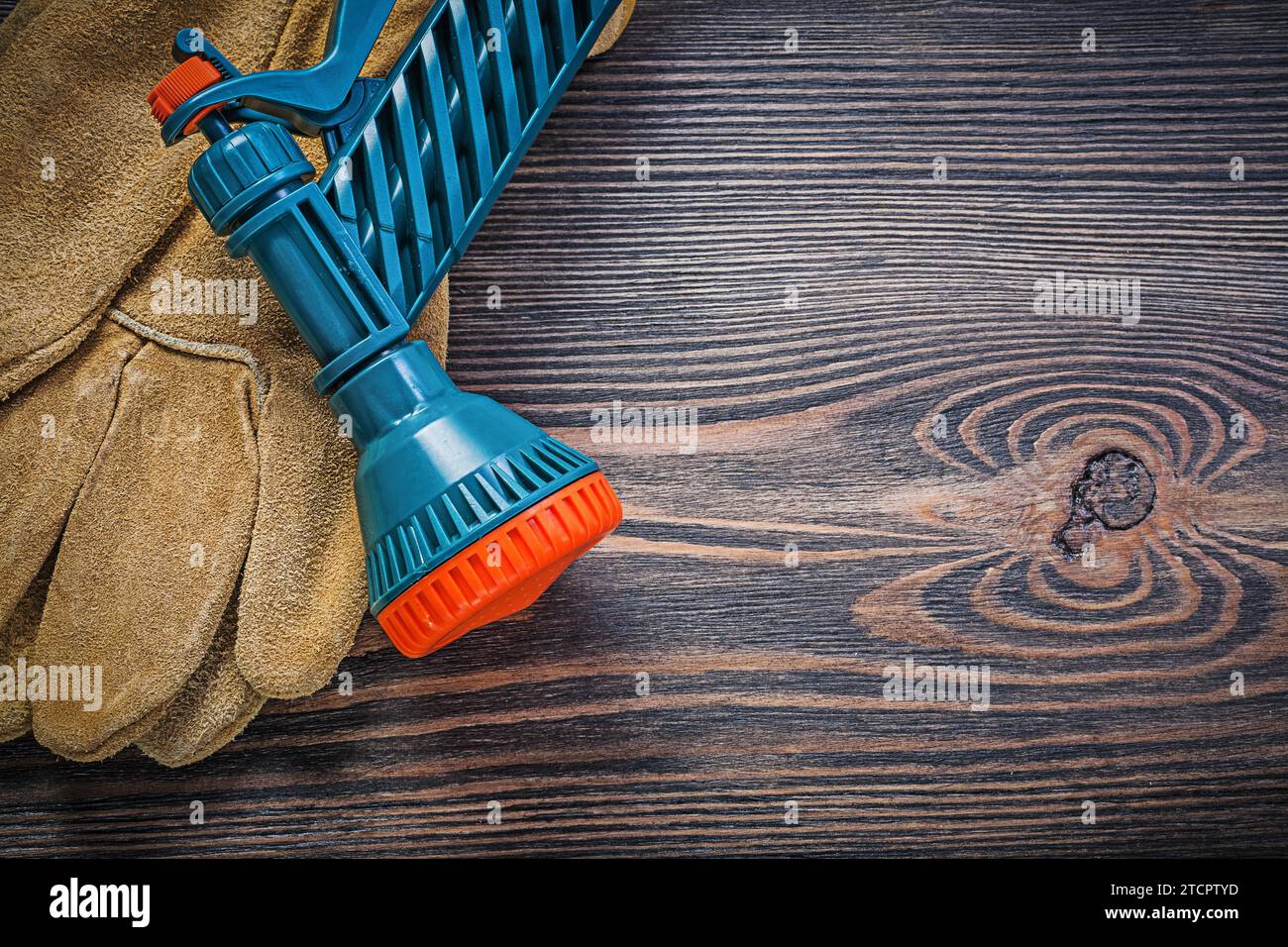 Garden Hand spray gun Protective gloves on wooden board Gardening concept Stock Photo