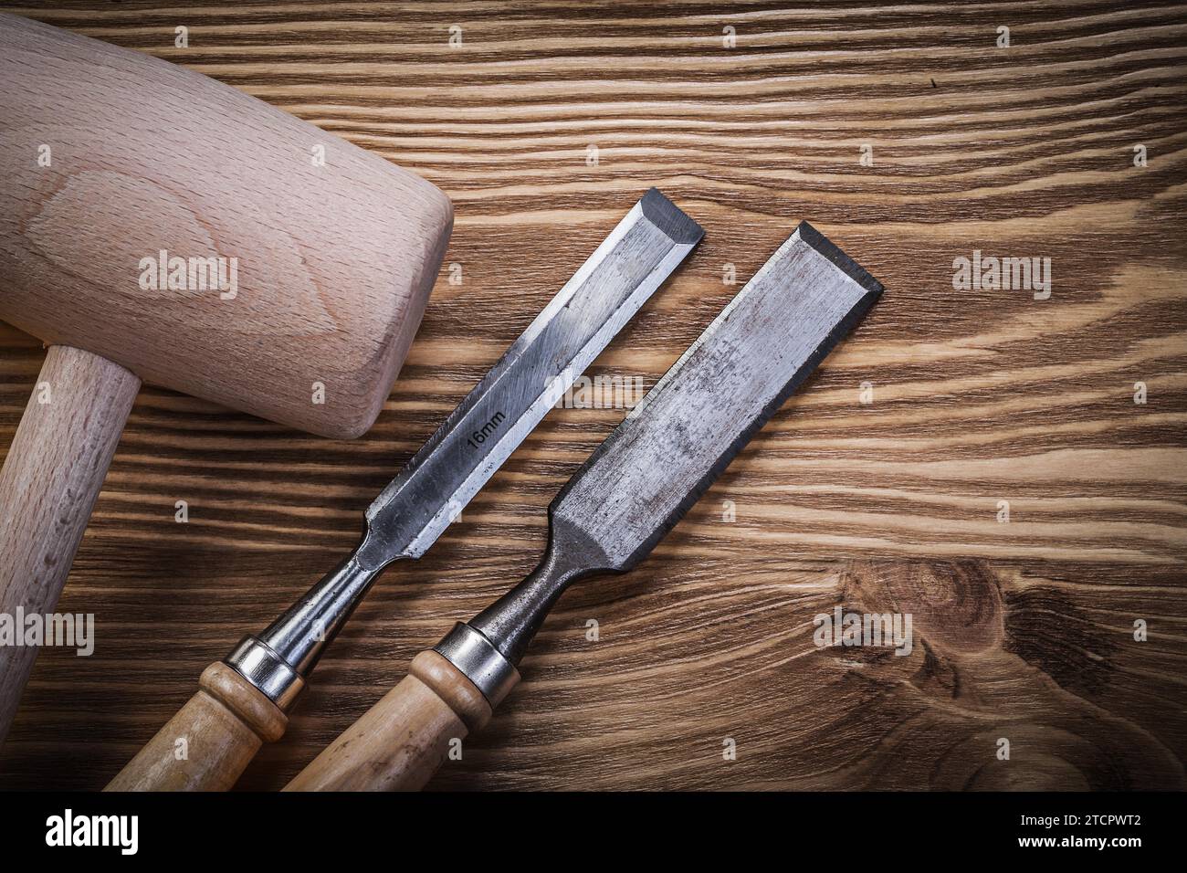 Lump hammer flat chisel on vintage wooden panel Building concept Stock Photo