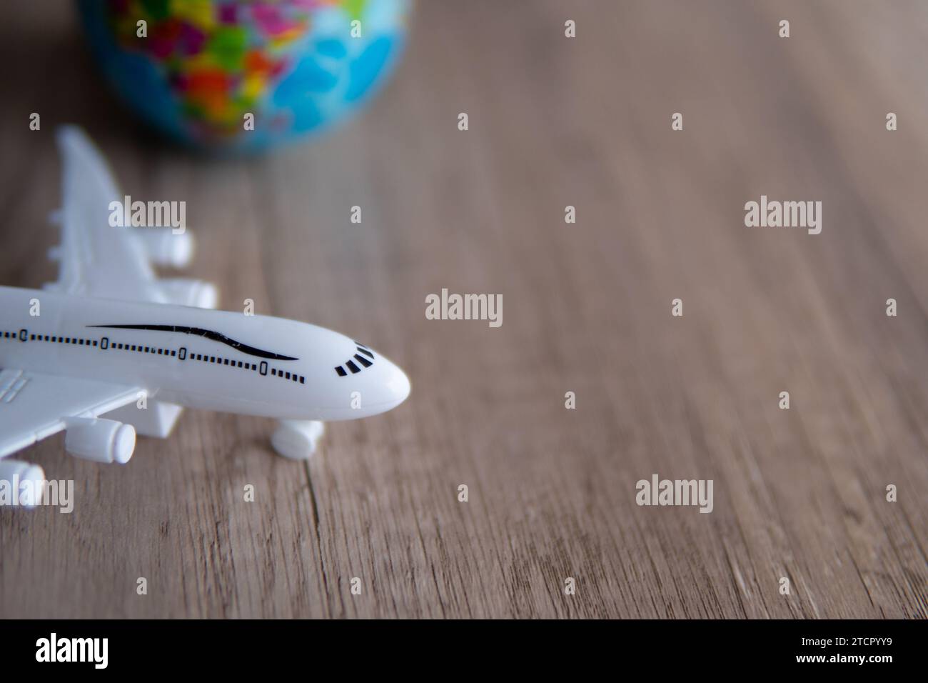 Closeup image of toy plane and earth globe on table with copy space. Travel concept. Stock Photo