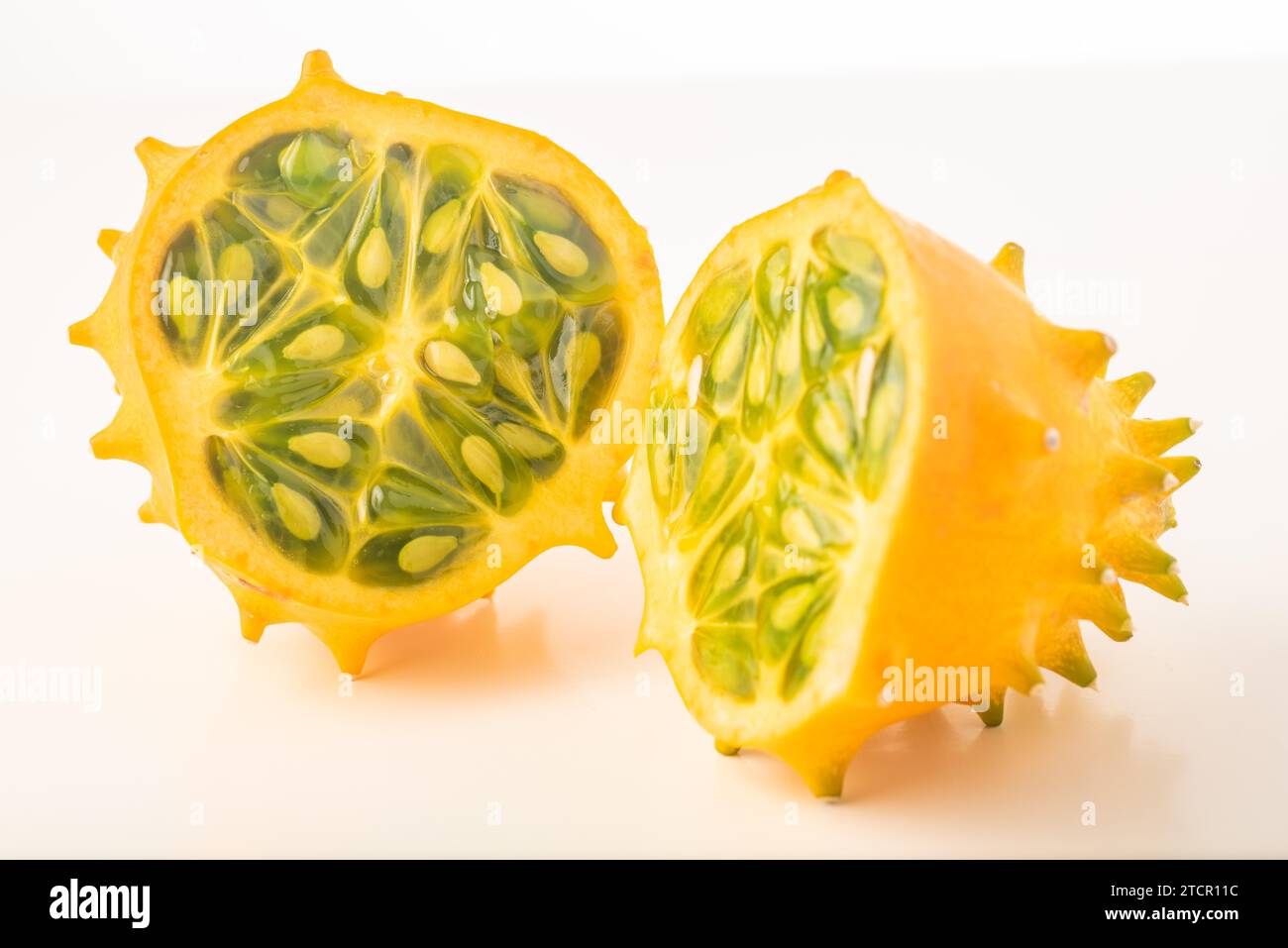 Kiwano or Horned Melon (Cucumis metuliferus) sliced in a half on white