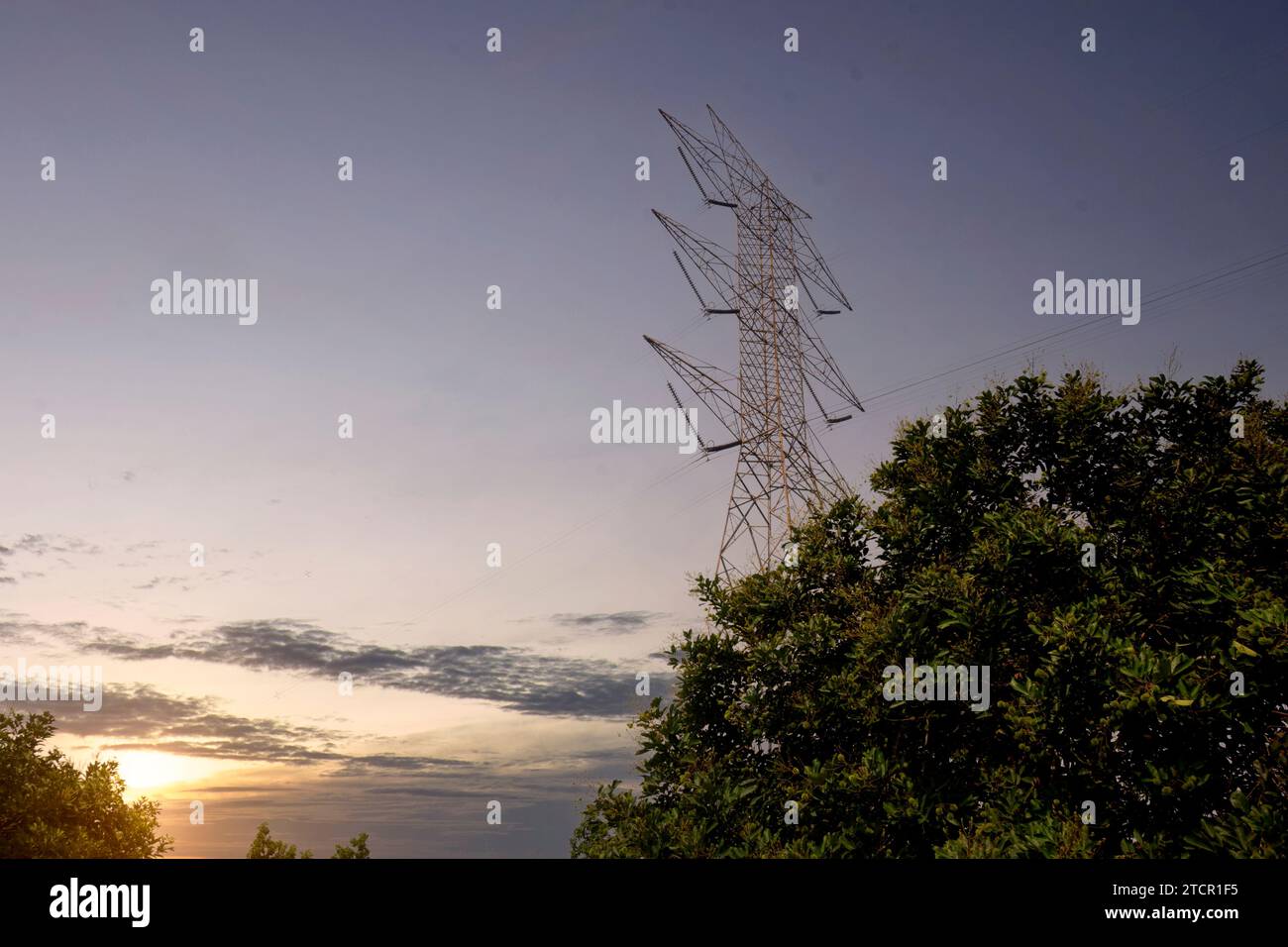 High voltage power lines tower with a sunset scene background Stock ...