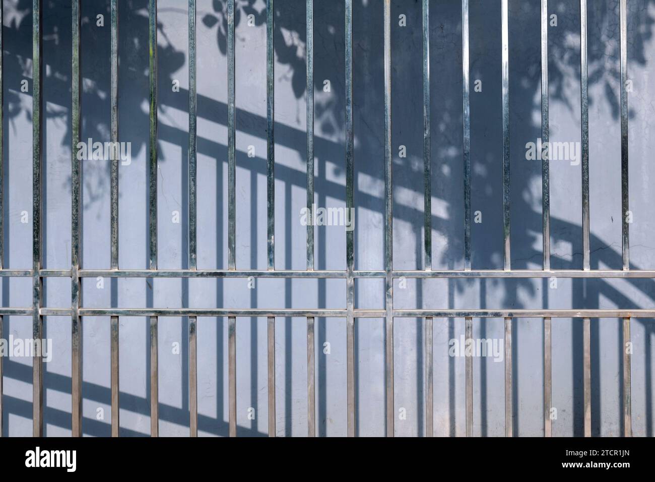 Iron fence with building wall background Stock Photo