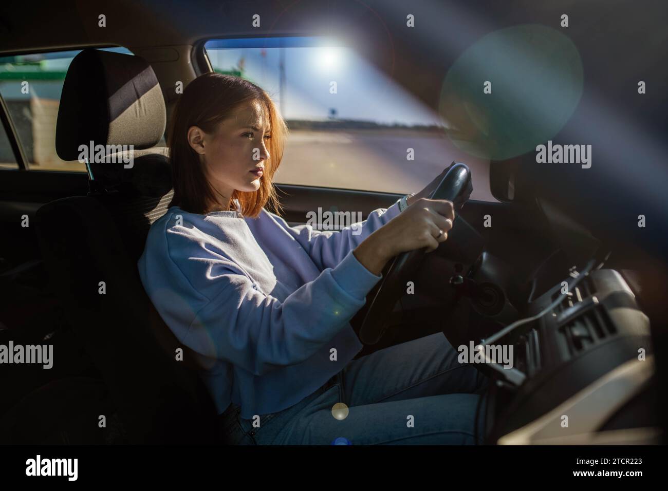Young beautiful woman driver driving a car, happy trip, spring travel Stock Photo