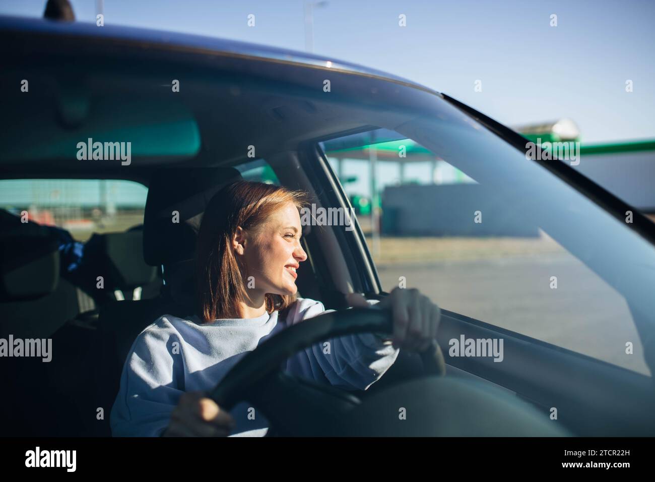 Young beautiful woman driver driving a car, happy trip, spring travel Stock Photo