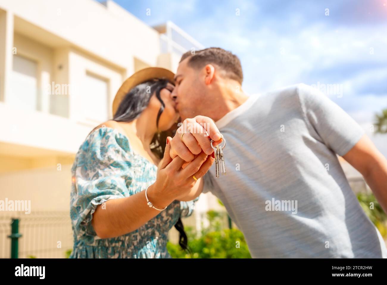 Happy couple kissing celebrating that they have bought a house Stock ...