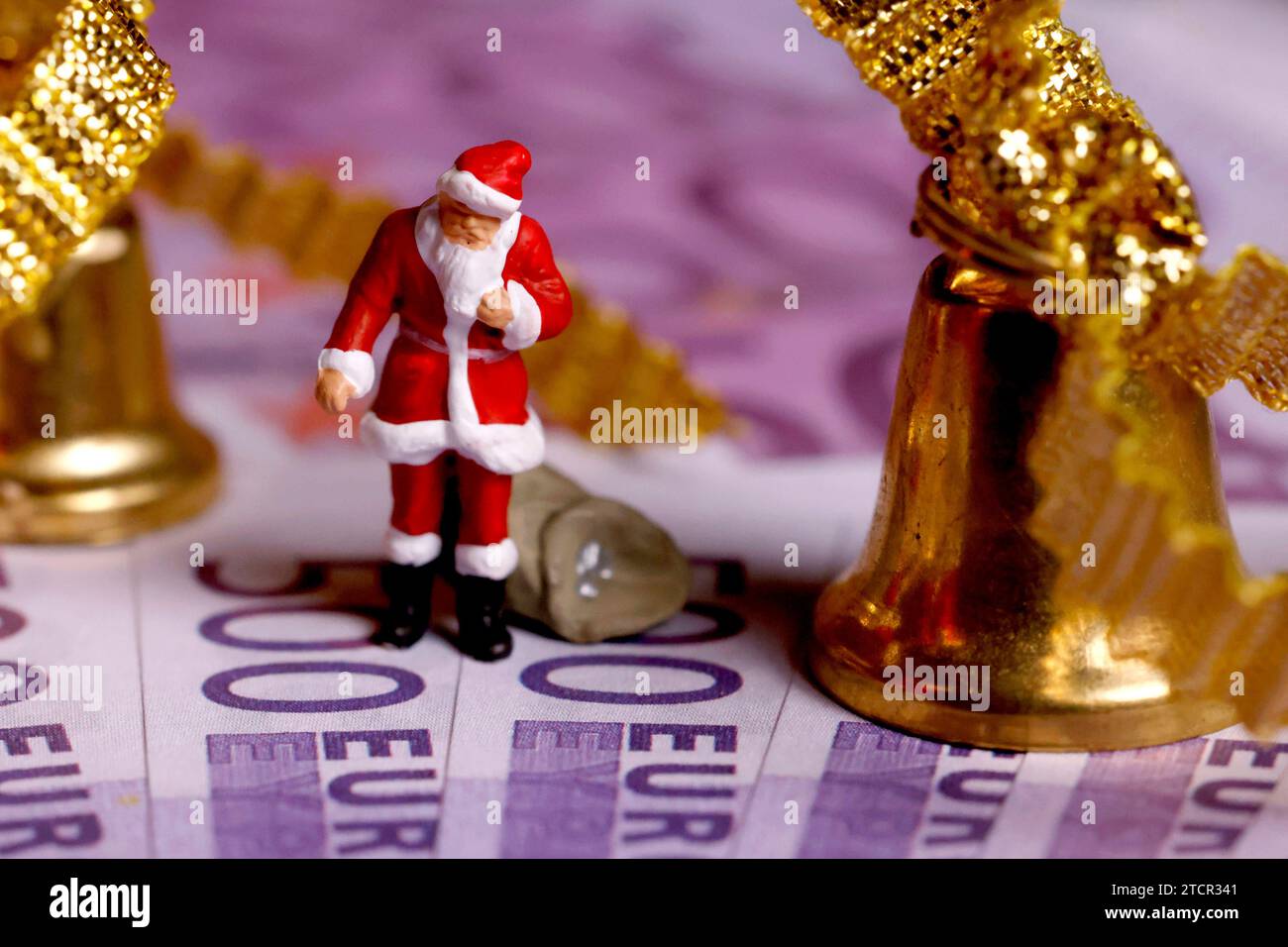 Ein Miniatur-Nikolaus zwischen Glöckchen steht auf Nachbildungen von 500-Euro-Scheinen. Viele Unternehmen beglücken ihre Mitarbeiter zum Jahresende mit der Zahlung eines Weihnachtsgeldes. Einen gesetzlichen Anspruch darauf gibt es jedoch nicht. Themenbild, Symbolbild Köln, 13.12.2023 NRW Deutschland *** A miniature Santa Claus between little bells stands on replicas of 500 euro bills Many companies treat their employees to a Christmas bonus at the end of the year However, there is no legal entitlement to this Themed image, symbolic image Cologne, 13 12 2023 NRW Germany Copyright: xChristophxHa Stock Photo