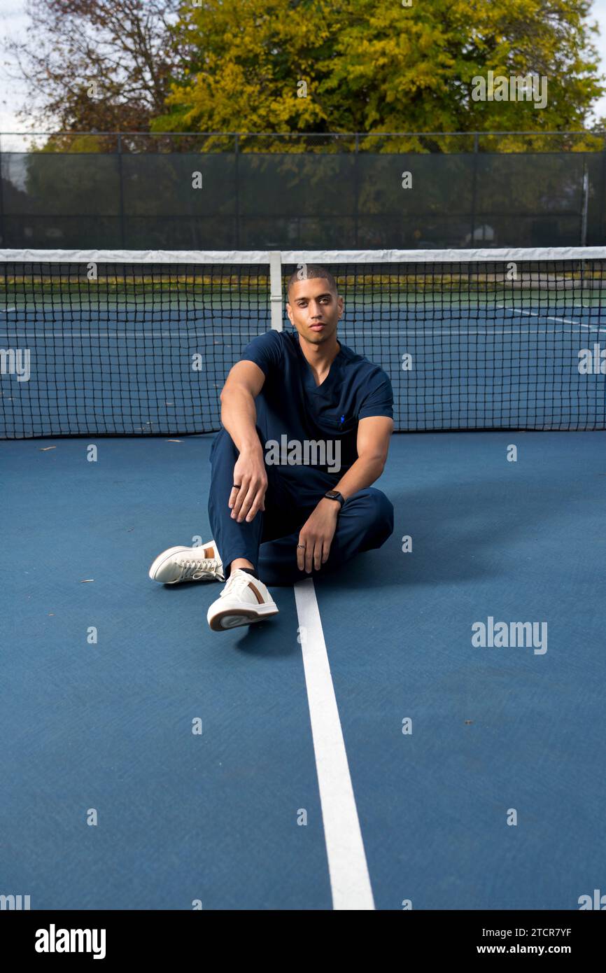 African American Doctor Wearing Scrubs Tennis Court in the Afternoon Stock Photo