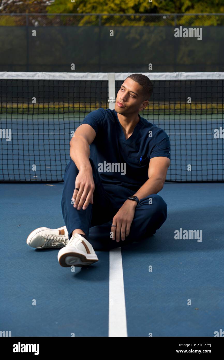 African American Doctor Wearing Scrubs Tennis Court in the Afternoon Stock Photo