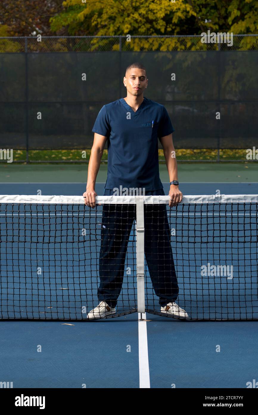 African American Doctor Wearing Scrubs Tennis Court in the Afternoon Stock Photo