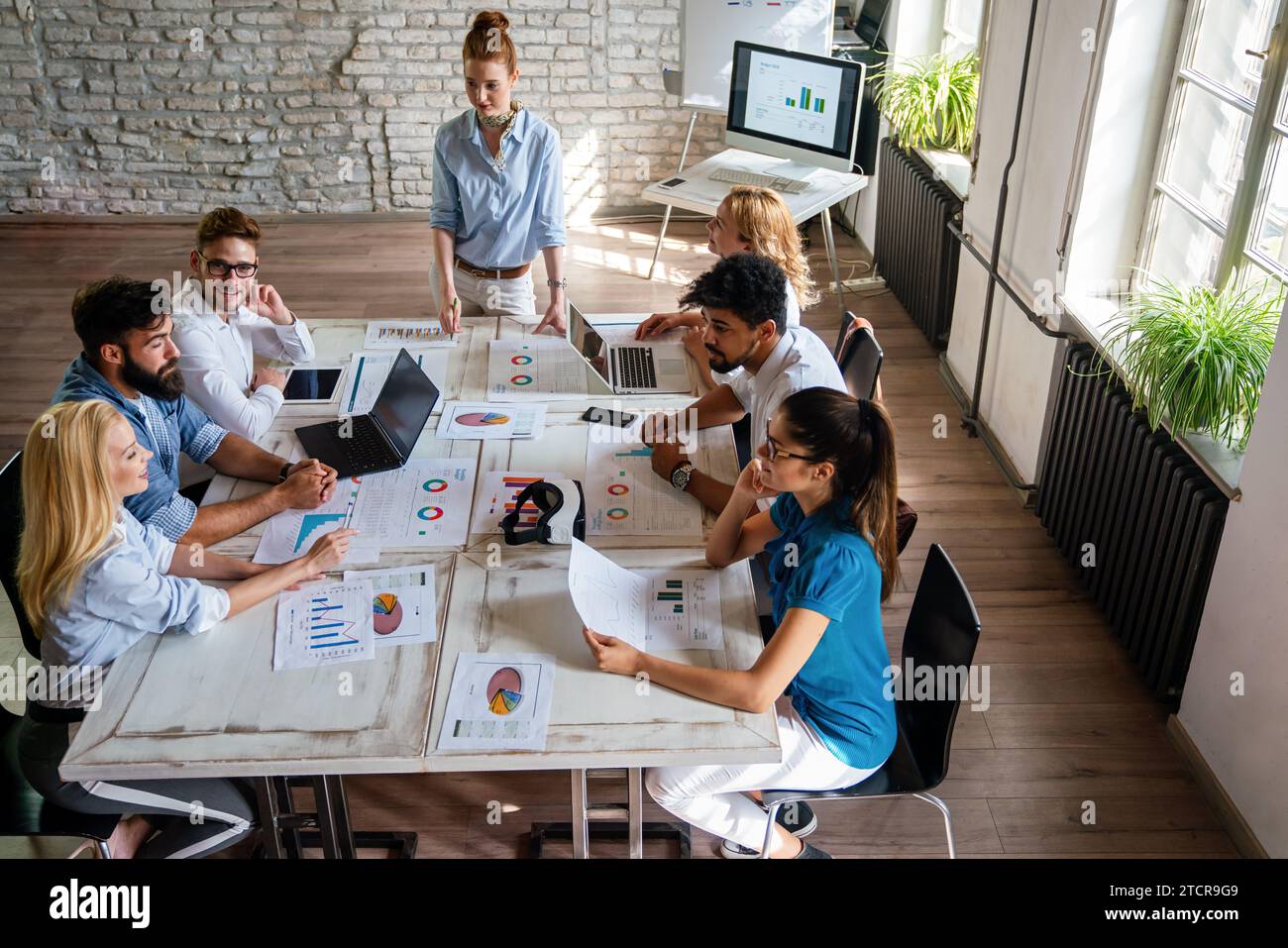 Smiling group of diverse businesspeople working together around a ...