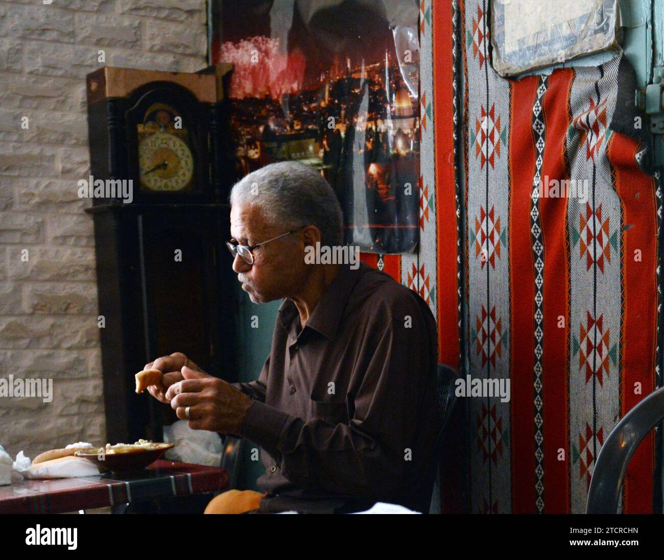 A Palestinian man eating hummus at Hummus Abu Kamel in the Christian quarter of the old city of Jerusalem. Stock Photo