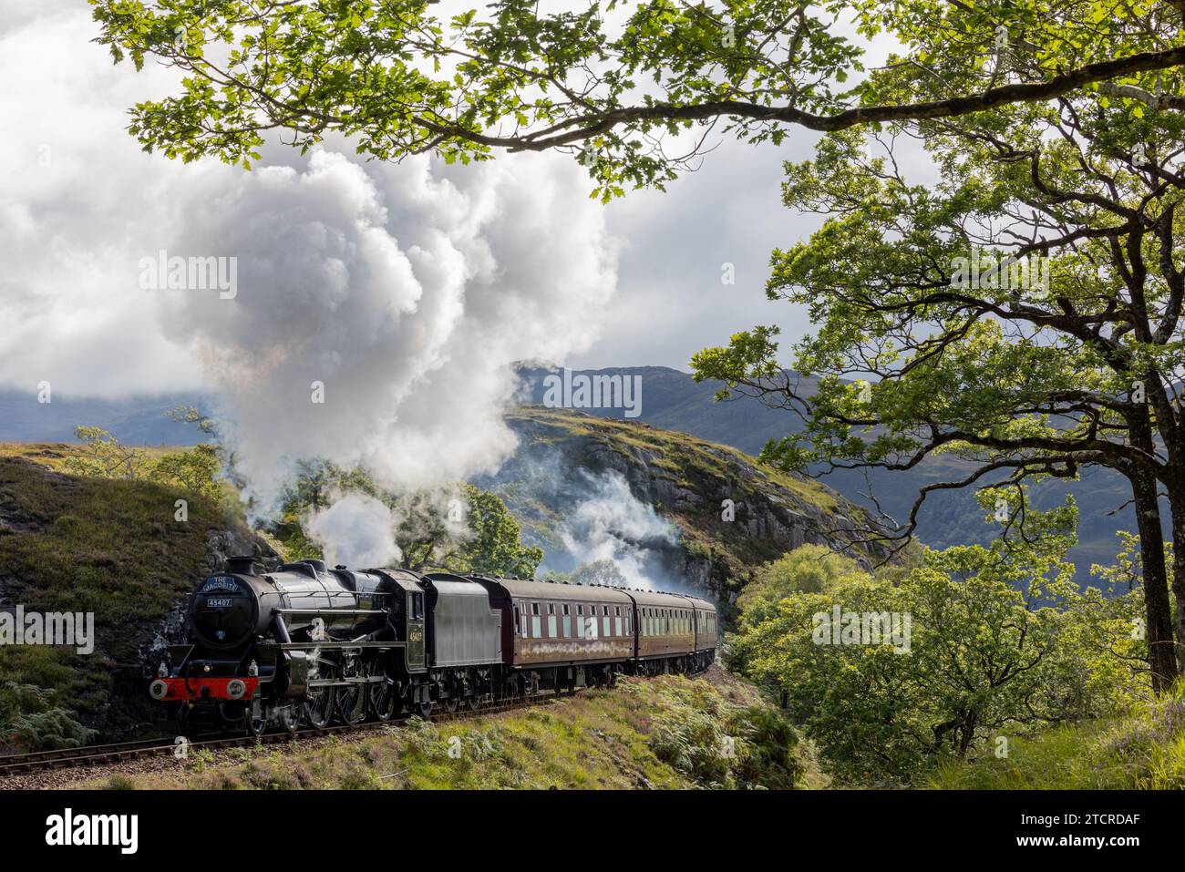 Steam train approaches the camera with billowing steam. Leading lines with steam and smoke. Fanous train used in Harry Potter as Hogwarts Express. Stock Photo
