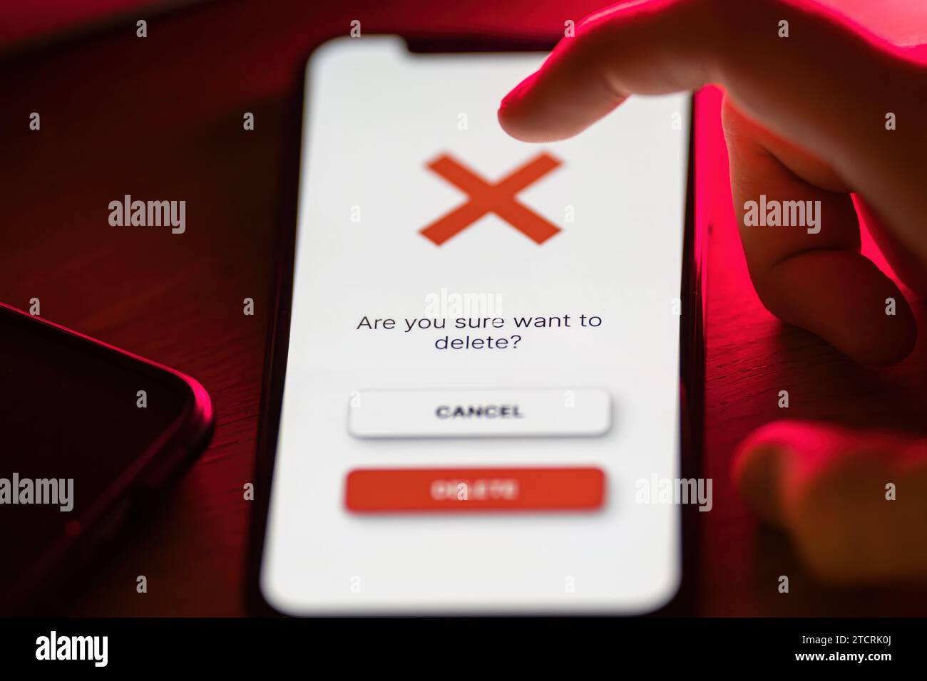 Clicking on red delete button on smartphone app Stock Photo
