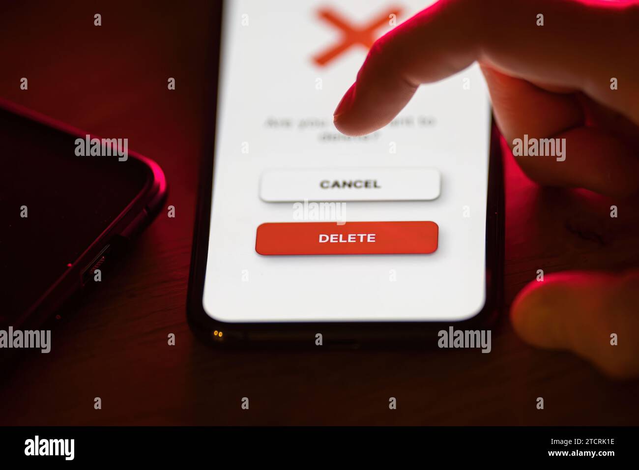 Clicking on red delete button on smartphone app Stock Photo