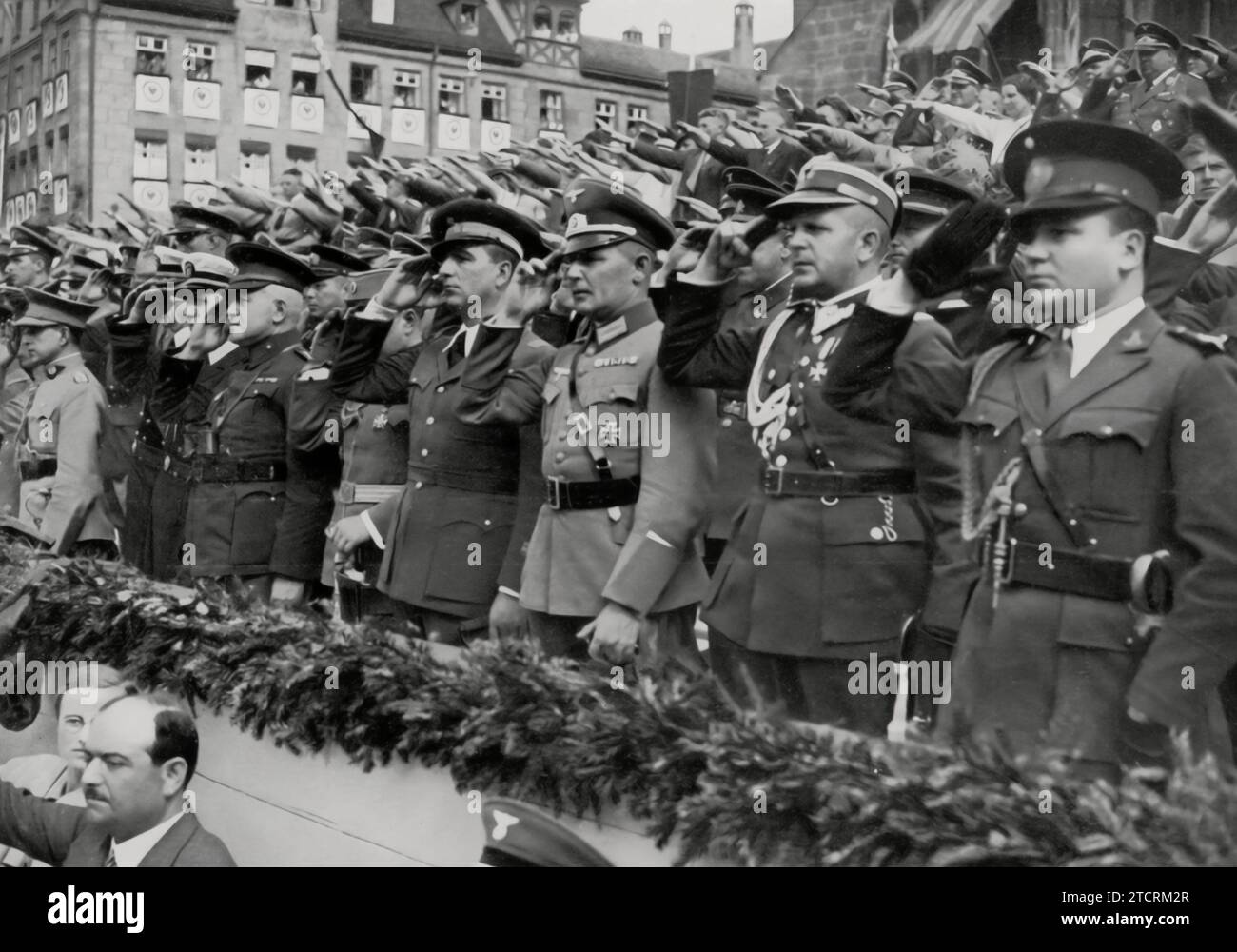 At the Nuremberg Party Rally, foreign military attachés are present, highlighting the international military interest in the events of the Nazi regime. Their attendance at such a highly propagandized event reflects the global military community's attention to the developments in Germany. These rallies, known for their grandiose displays and speeches, were not only domestic propaganda tools but also served to showcase Nazi military and political might to an international audience. Stock Photo