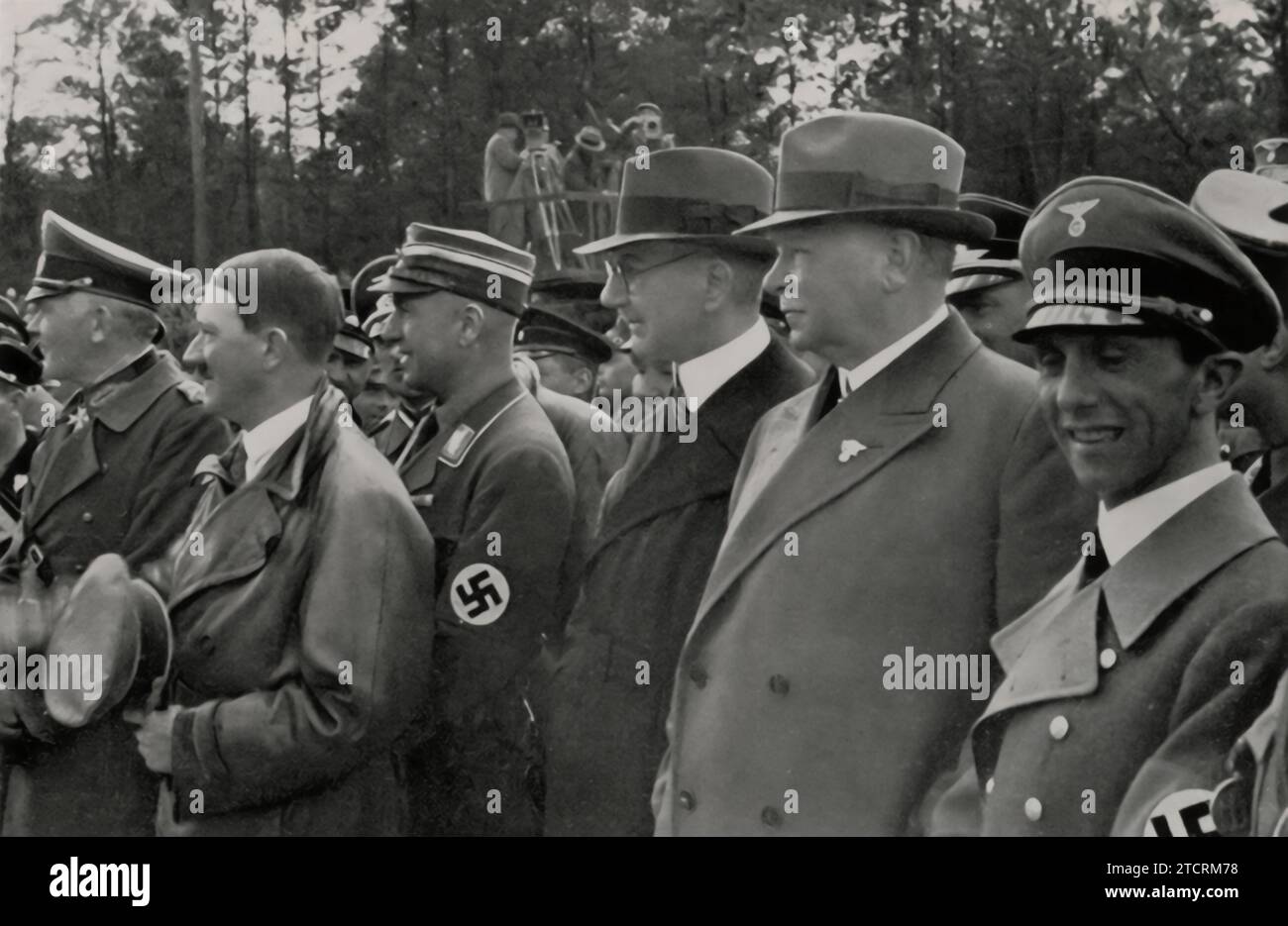 At the 1935 inauguration of the Reichsautobahn section between Frankfurt and Darmstadt, key figures gather, illustrating the Nazi leadership's emphasis on infrastructure. From left to right, Reich War Minister von Blomberg, Adolf Hitler, General Inspector Dr. Todt, Reichsbank President Dr. Schacht, Reichsbahn Director Dr. Dorpmüller, and Reich Minister Dr. Goebbels are present. This assembly of high-ranking officials underscores the regime's investment in the autobahn project, a symbol of technological advancement and national progress. Stock Photo
