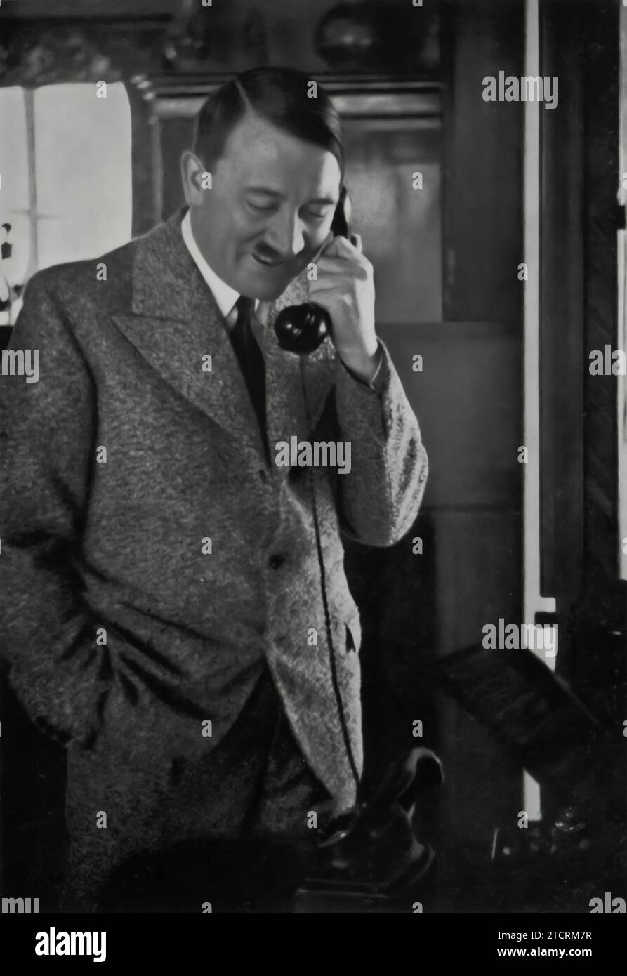 Adolf Hitler, visibly pleased, is on the phone on the morning of January 15, 1935, expressing his thanks to Gauleiter Josef Bürckel. Bürckel played a key role in the Nazi campaign for the Saar plebiscite, where a decisive 90% voted for reunification with Germany. This photo captures a significant moment of triumph for the Nazi propaganda, highlighting their increasing dominance. Stock Photo