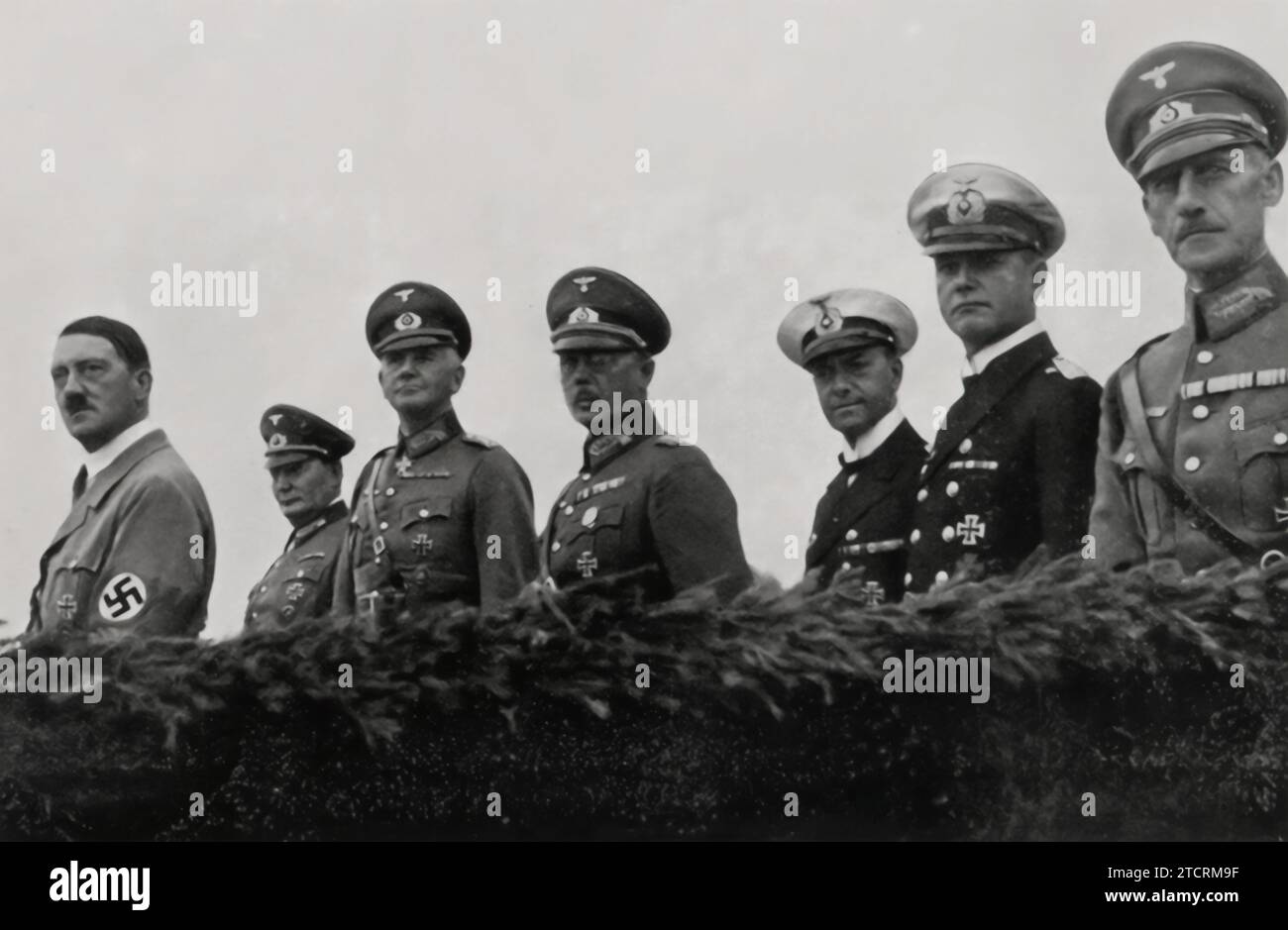 On the Day of the Armed Forces in 1935, Adolf Hitler is pictured with his top commanders, showcasing the hierarchy of military leadership in Nazi Germany. From left to right: Generaloberst Hermann Göring, Commander-in-Chief of the Luftwaffe; Generalfeldmarschall Werner von Blomberg, Minister of War; Generaloberst Freiherr von Fritsch, Commander-in-Chief of the Army; and Generaladmiral Dr. h.c. Erich Raeder, Commander-in-Chief of the Kriegsmarine. This gathering illustrates the consolidation of military power and the diverse branches under Hitler's command. Stock Photo