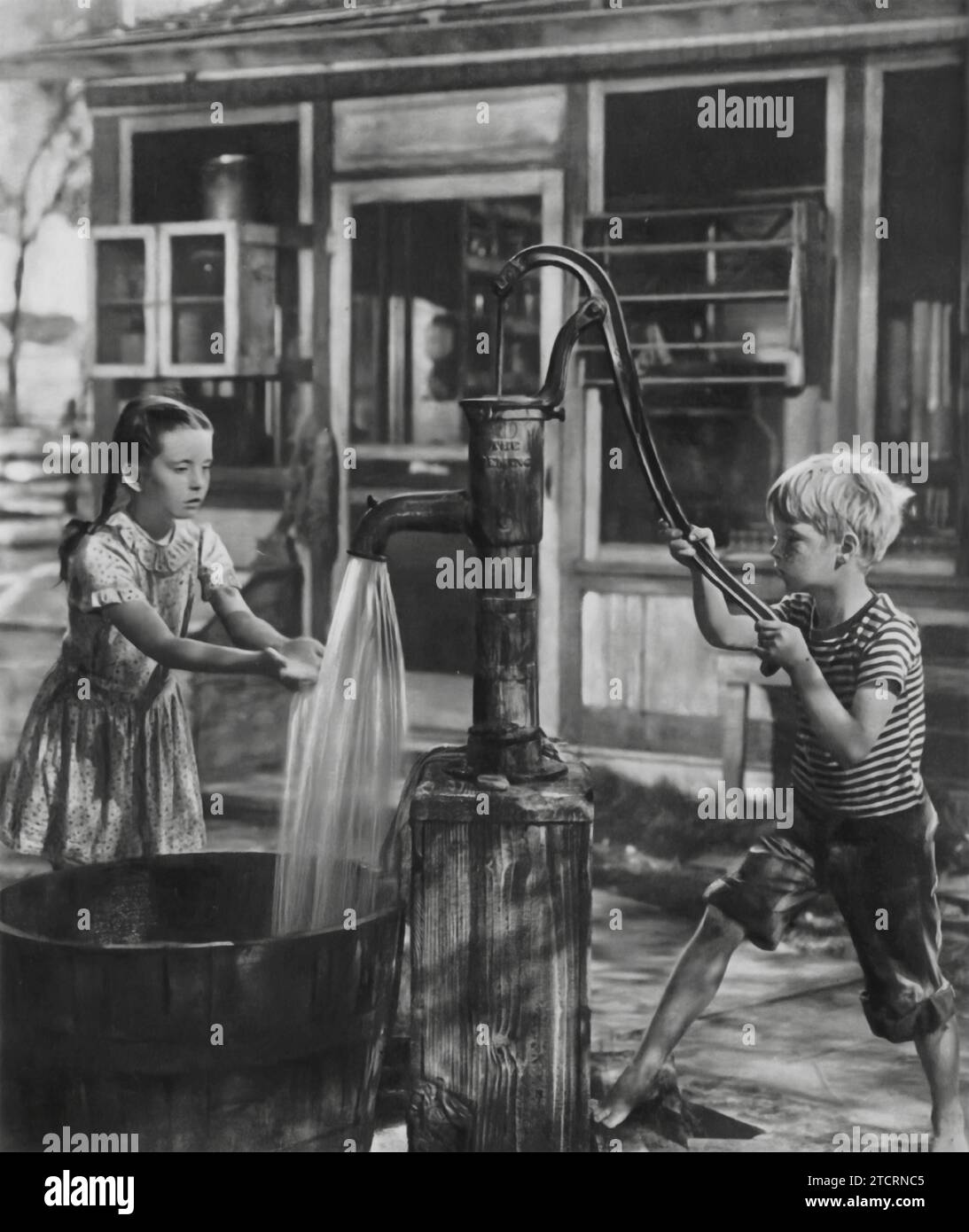 Margaret O'Brien and Jackie Jenkins are captured in a poignant scene by a water well in the film 'Our Vines Have Tender Grapes' (1945). Set in the heartland of America, the movie offers a touching portrayal of rural life and the simple joys and challenges faced by its residents. O'Brien plays Selma Jacobson, while Jenkins takes on the role of her friend, Arnold Hanson. Stock Photo