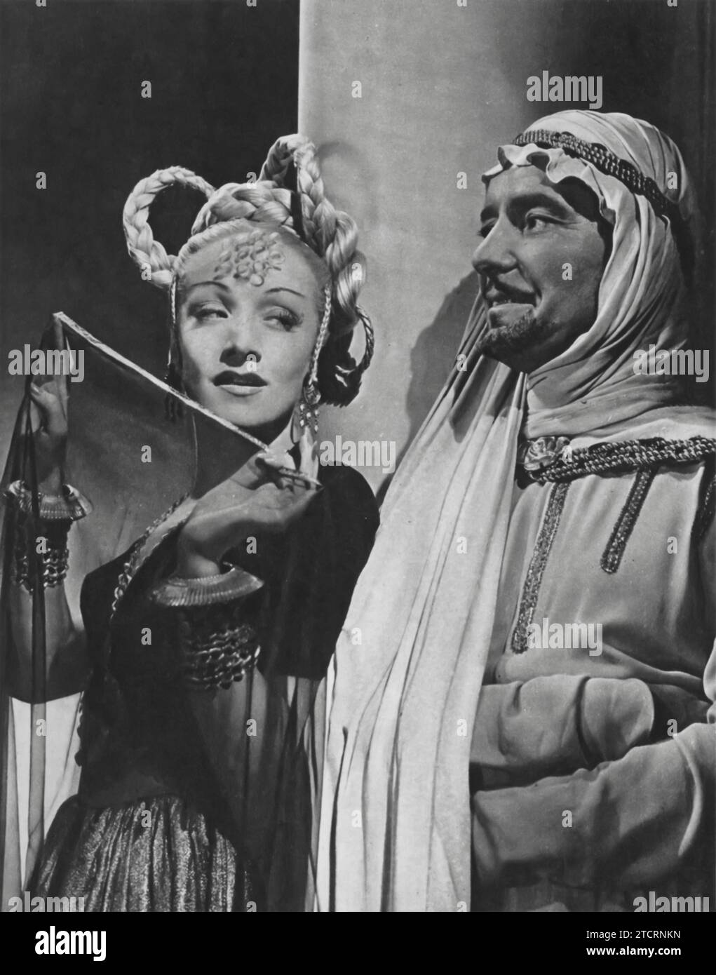 Marlene Dietrich and Ronald Colman starred in 'Kismet' (1944). Colman plays a poet who finds himself in a whirlwind of adventures after a theft. Adapted from a stage musical, 'Kismet' is a blend of drama and romance, showcasing the talents of these Hollywood icons Stock Photo