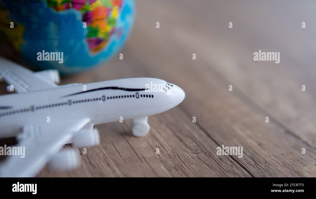Closeup image of toy plane and earth globe on table with copy space. Travel concept. Stock Photo