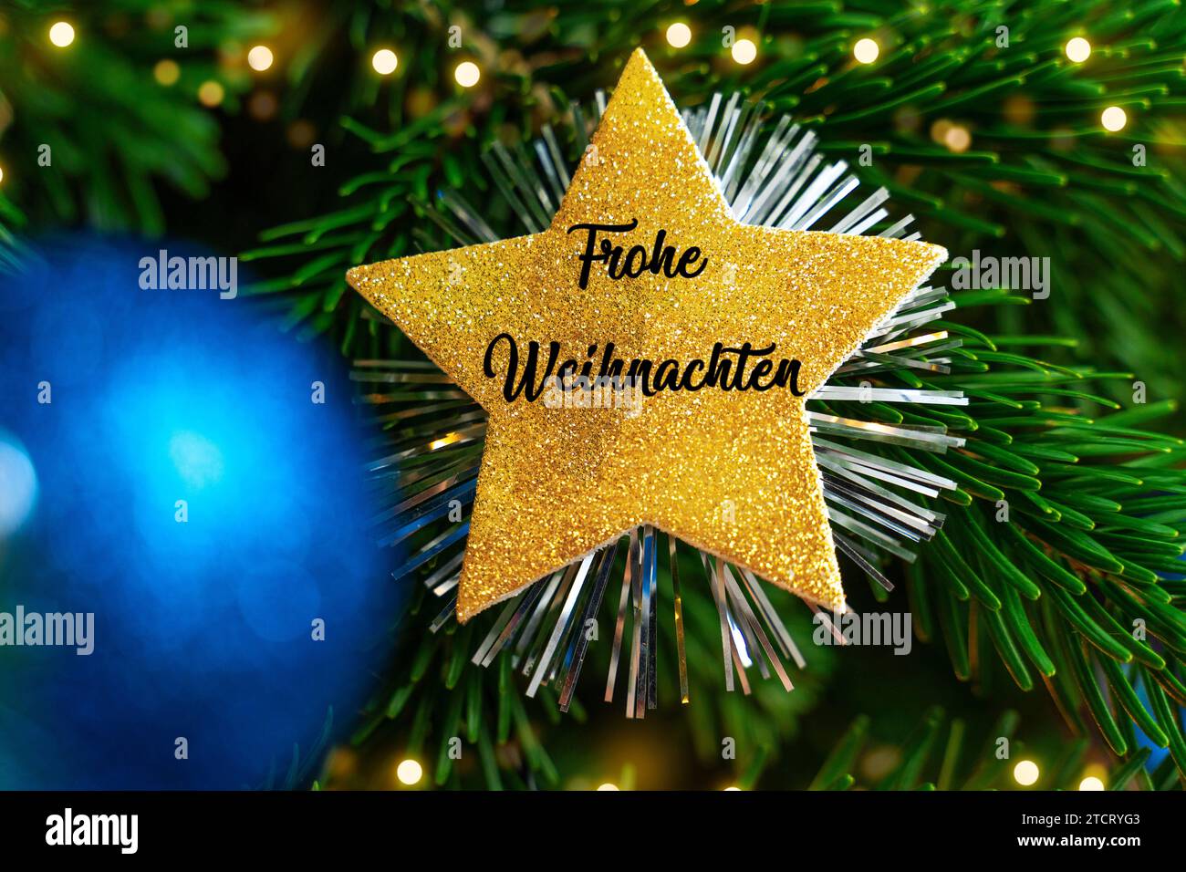 13 December 2023: Merry Christmas lettering on a golden star on a Christmas tree FOTOMONTAGE *** Frohe Weihnachten Schriftzug auf einem goldenen Stern an einem Weihnachtsbaum FOTOMONTAGE Stock Photo