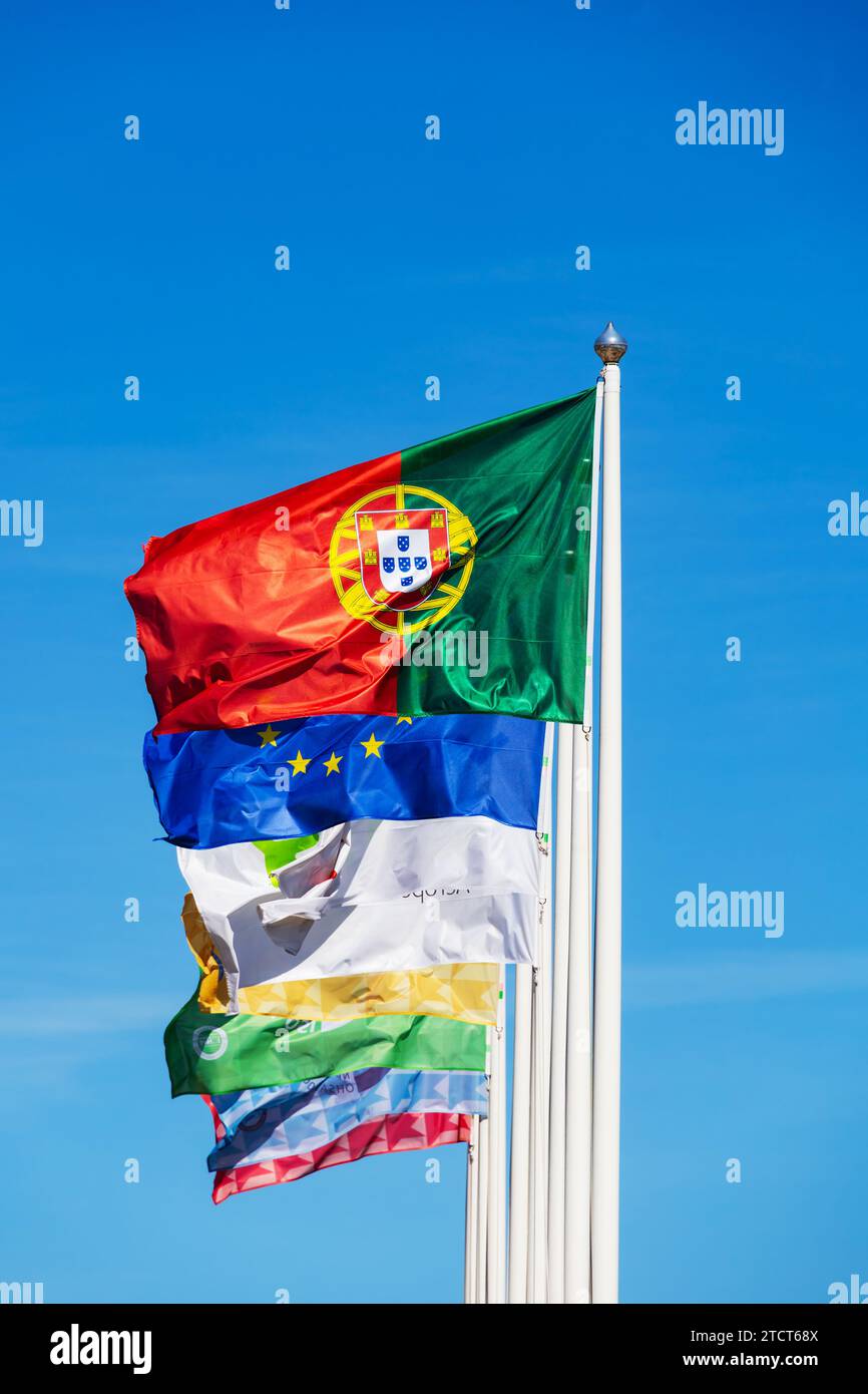 Portuguese national flag flying with European Union flag and corporate flags outside Lisbon Airport. Stock Photo