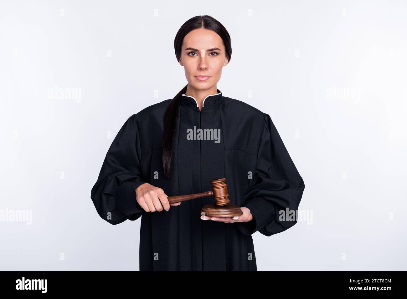 Photo of serious beautiful woman judge attorney in black robe using