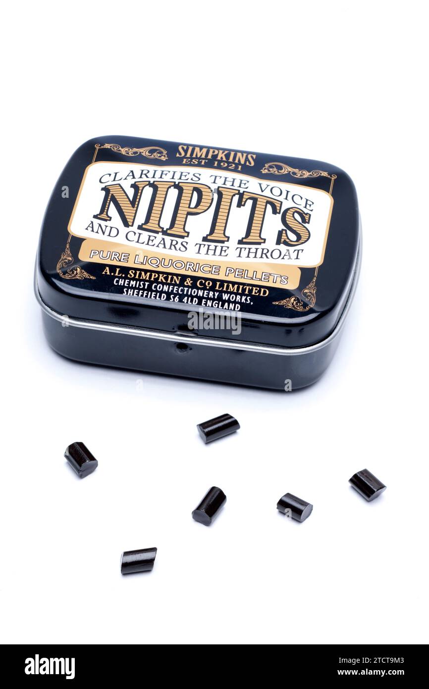 Tin of Simpkins Nipits Pure Liquorice Pellets Spilling  onto a White Background for Clearing the Throat Stock Photo