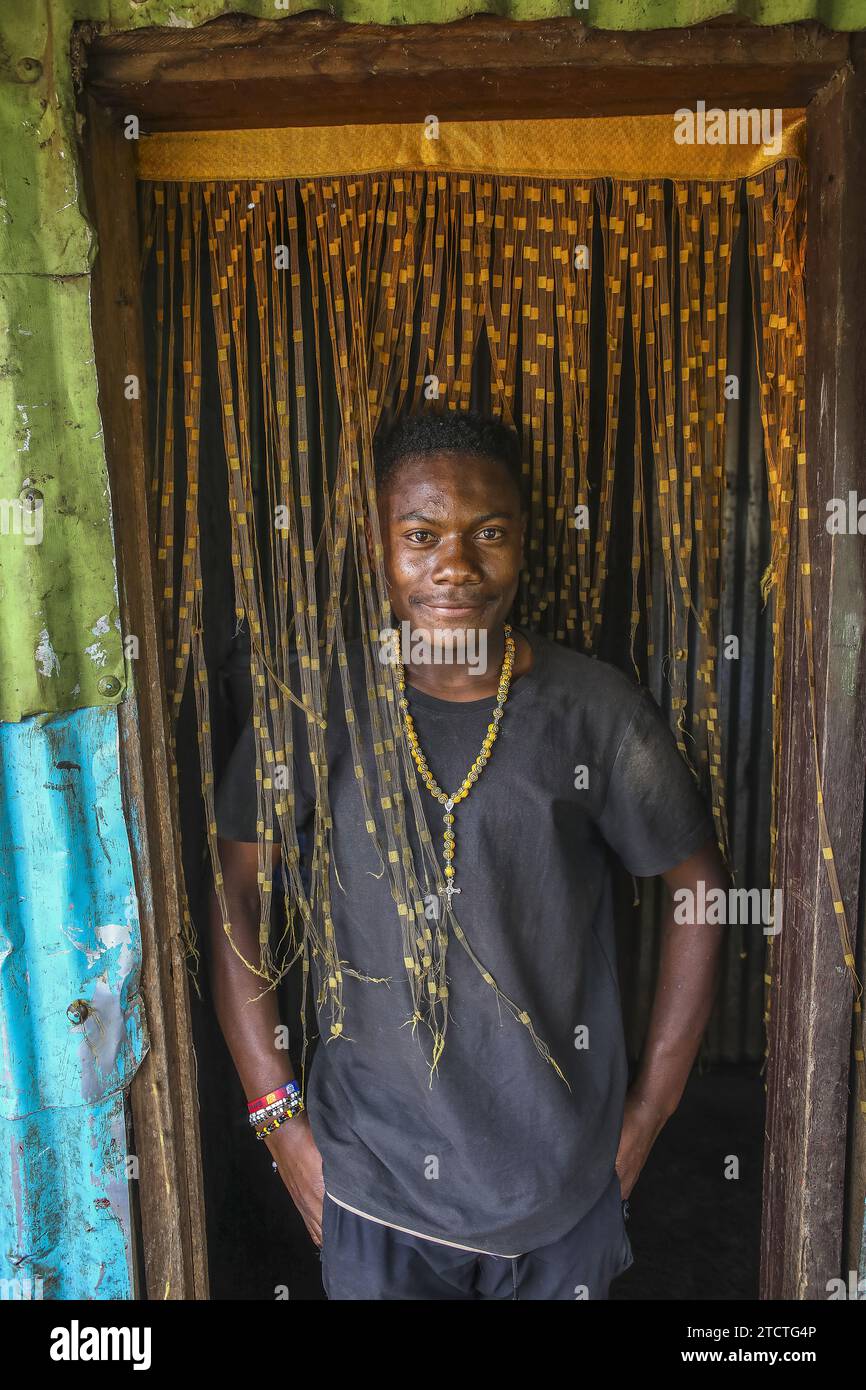 Young Congolese standing on the threshold of his home in Bukavu, DRC Stock Photo