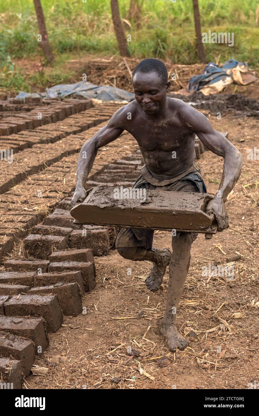 Worker making clay bricks in a village near Lake Albert, Uganda Stock