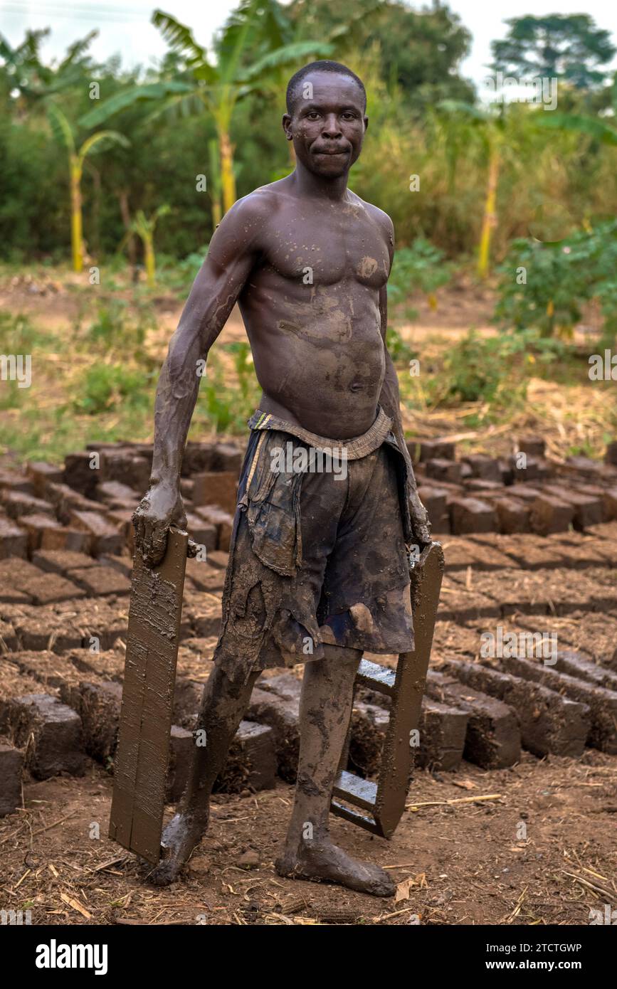 Worker making clay bricks in a village near Lake Albert, Uganda Stock