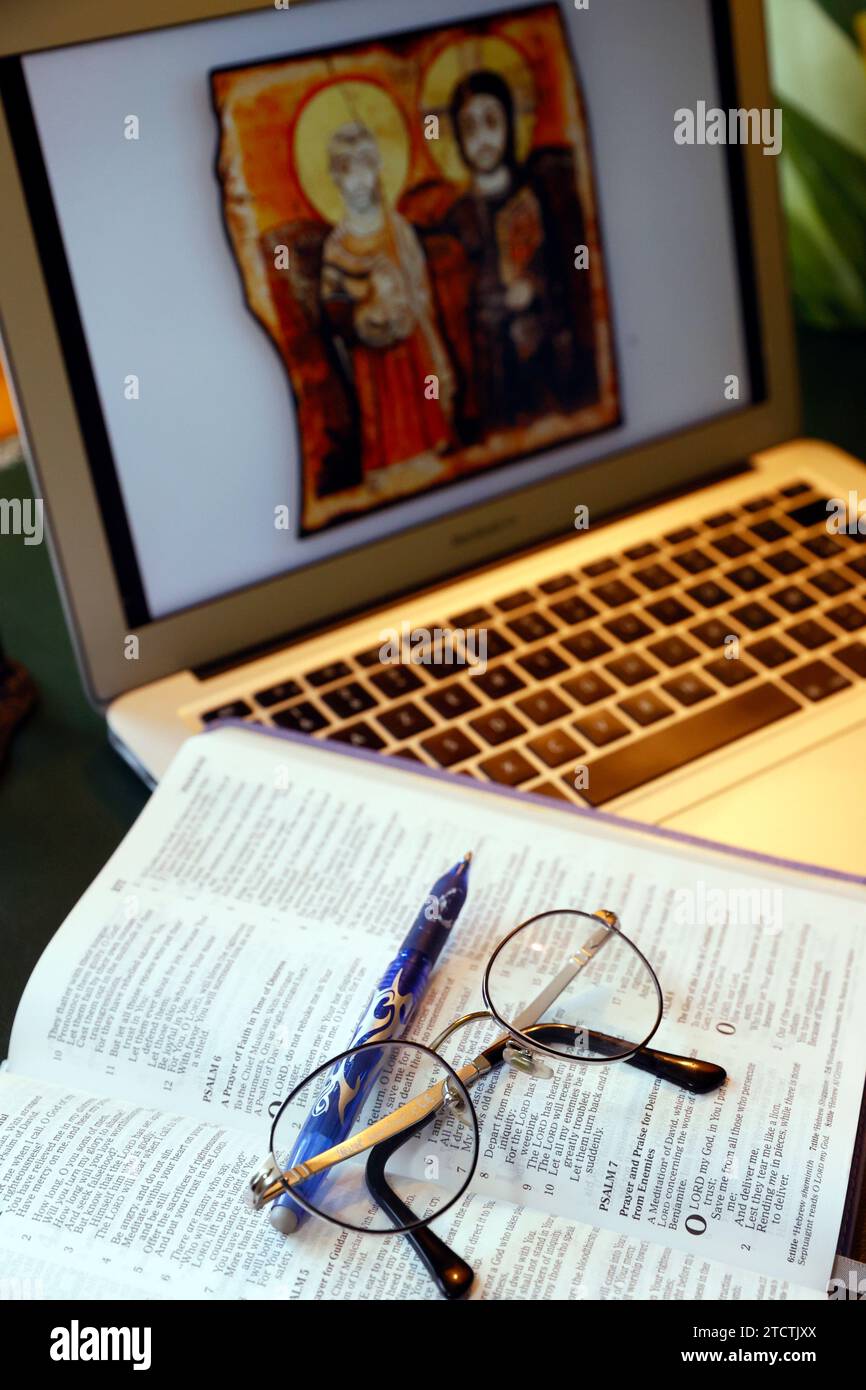 Bible study. Laptop and open bible with glasses. Stock Photo