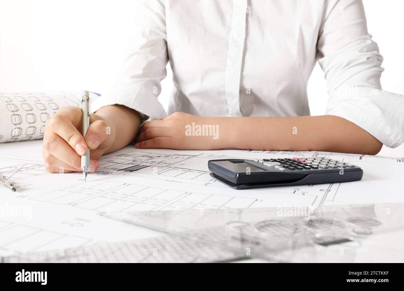 Female engineer designing architectural blueprints at office desk Stock Photo