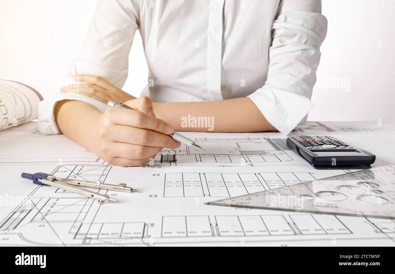 Female engineer designing architectural blueprints at office desk Stock Photo