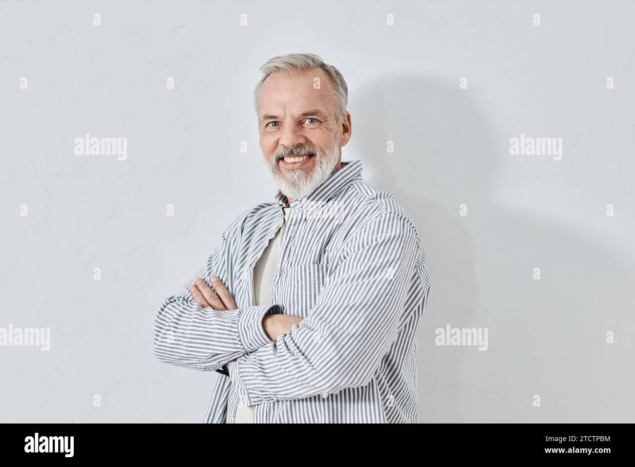 Happy Aged Man Crossing Hands Smiling at Camera Stock Photo