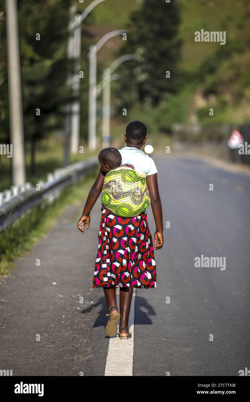 Siblings Rwanda Girl carrying sibling on a road in western rwanda Stock Photo - Alamy