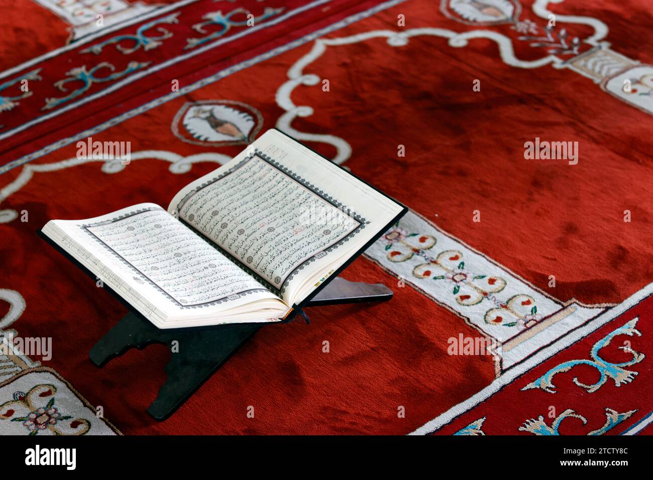Mubarak mosque. Open Quran in arabic on wood stand. Symbol of Islam