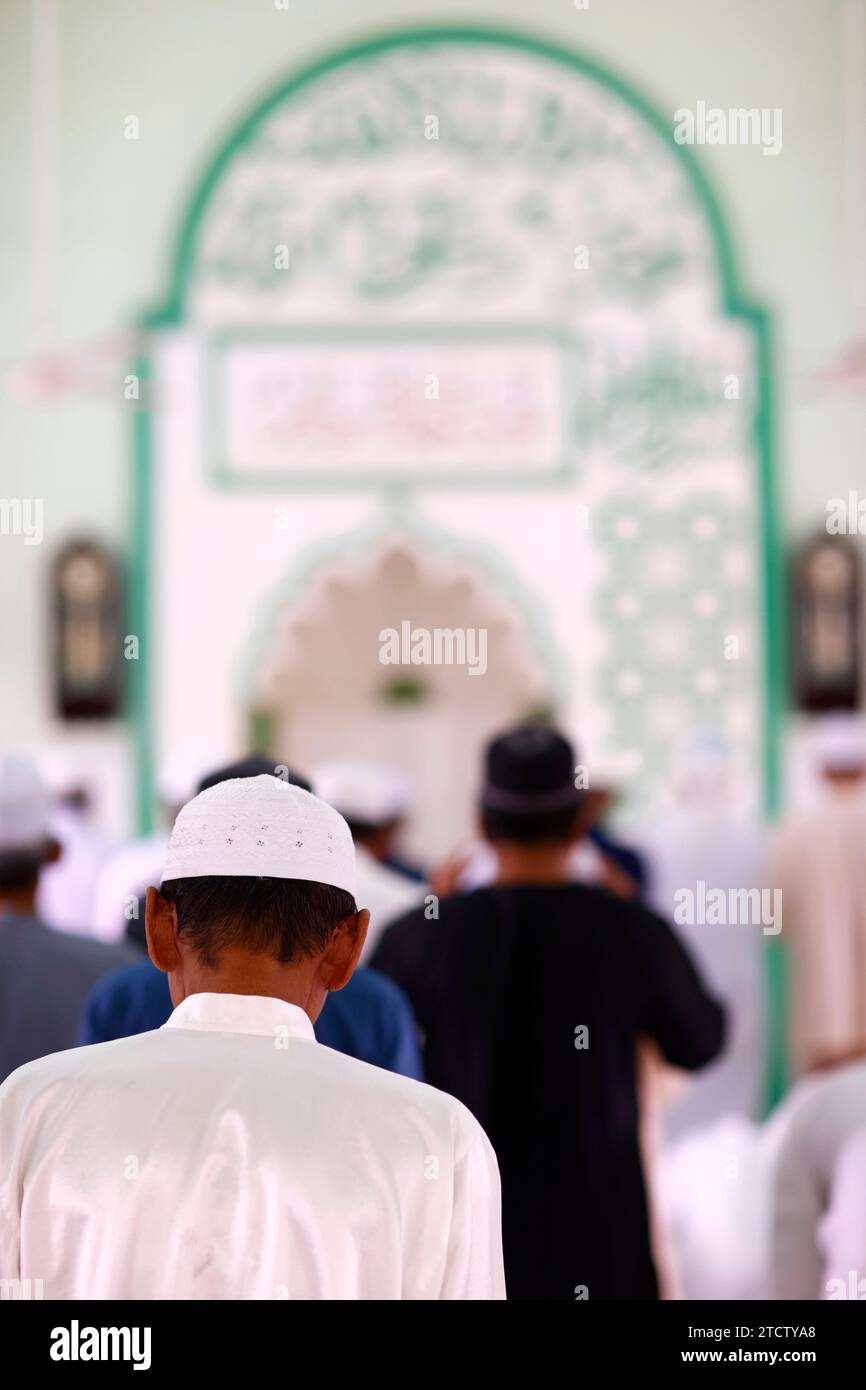 Jamiul Azhar mosque.  The friday prayer (salat). Muslim men praying in mosque. Vietnam. Stock Photo