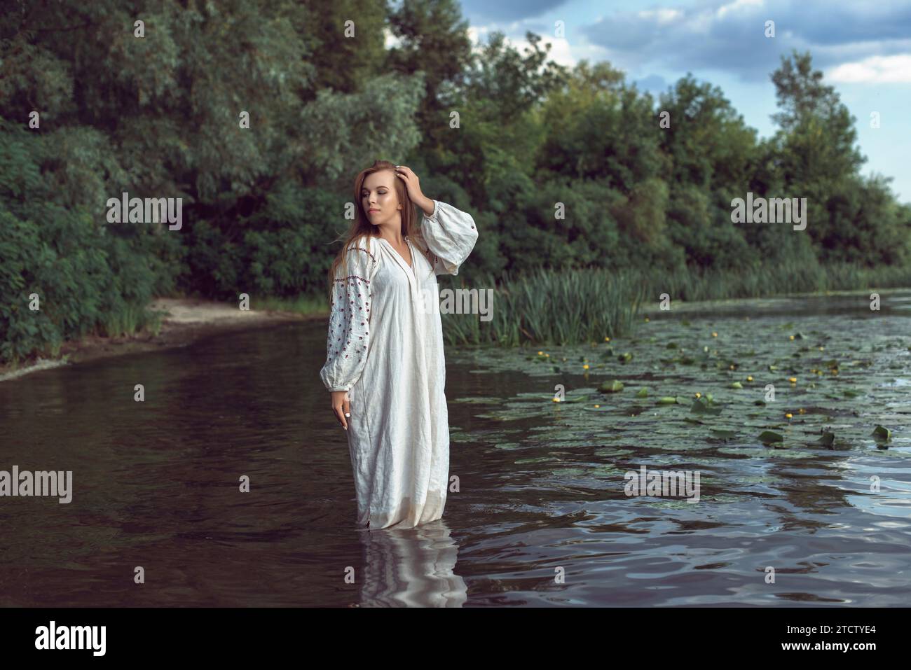 Girl in an embroidered dress on the lake Stock Photo - Alamy