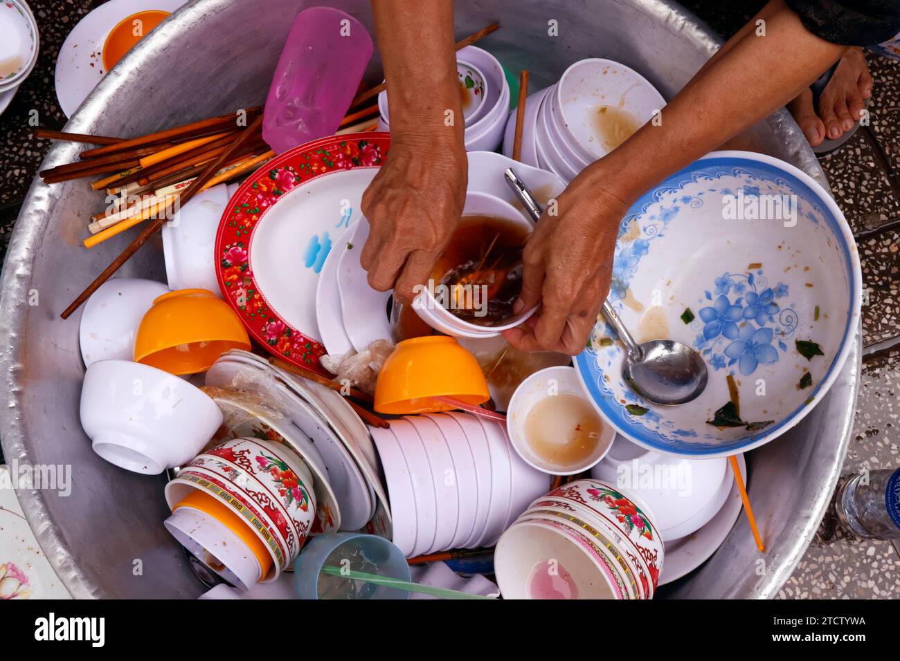 Kitchen help washing the dishes behind a restaurant. Stock Photo