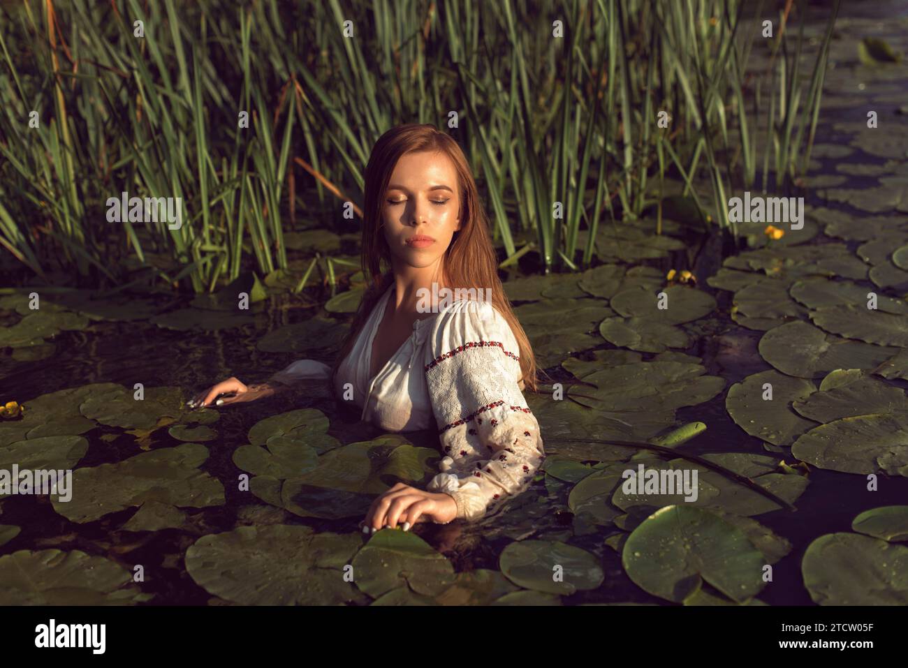 Girl in an embroidered dress on the lake Stock Photo - Alamy