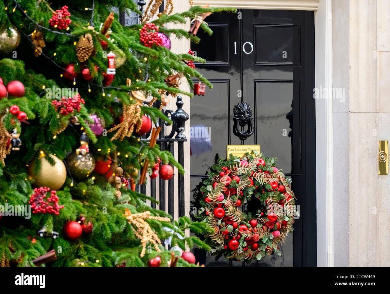 London, UK. Christmas tree and Christmas wreath on the door of 10 Downing Street, December 2023 (Door in focus) Stock Photo