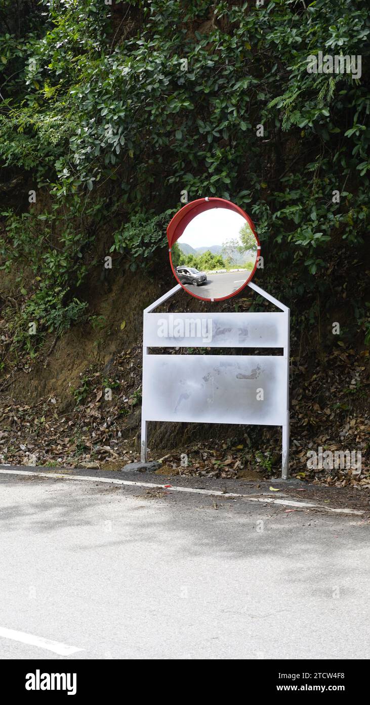 Outdoor traffic convex mirror in the hairpin bends and uphill road enroute to kodaikanal hilltop. Installed for improving safety. Stock Photo