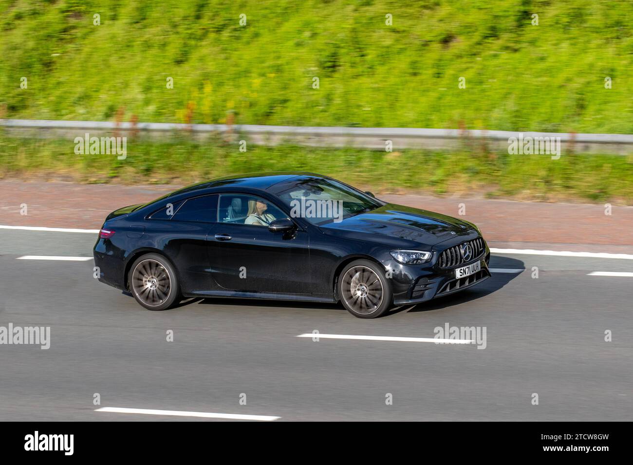 2021 Black Mercedes-Benz E 300 Amg Ln Ngt Ed Prm+Mhev A E300 9G-Tronic Auto MHEV EQ Boost 272 14Hp/10Kw Start/Stop Car Coupe Hybrid Electric1991 cc travelling on the M6 motorway UK Stock Photo