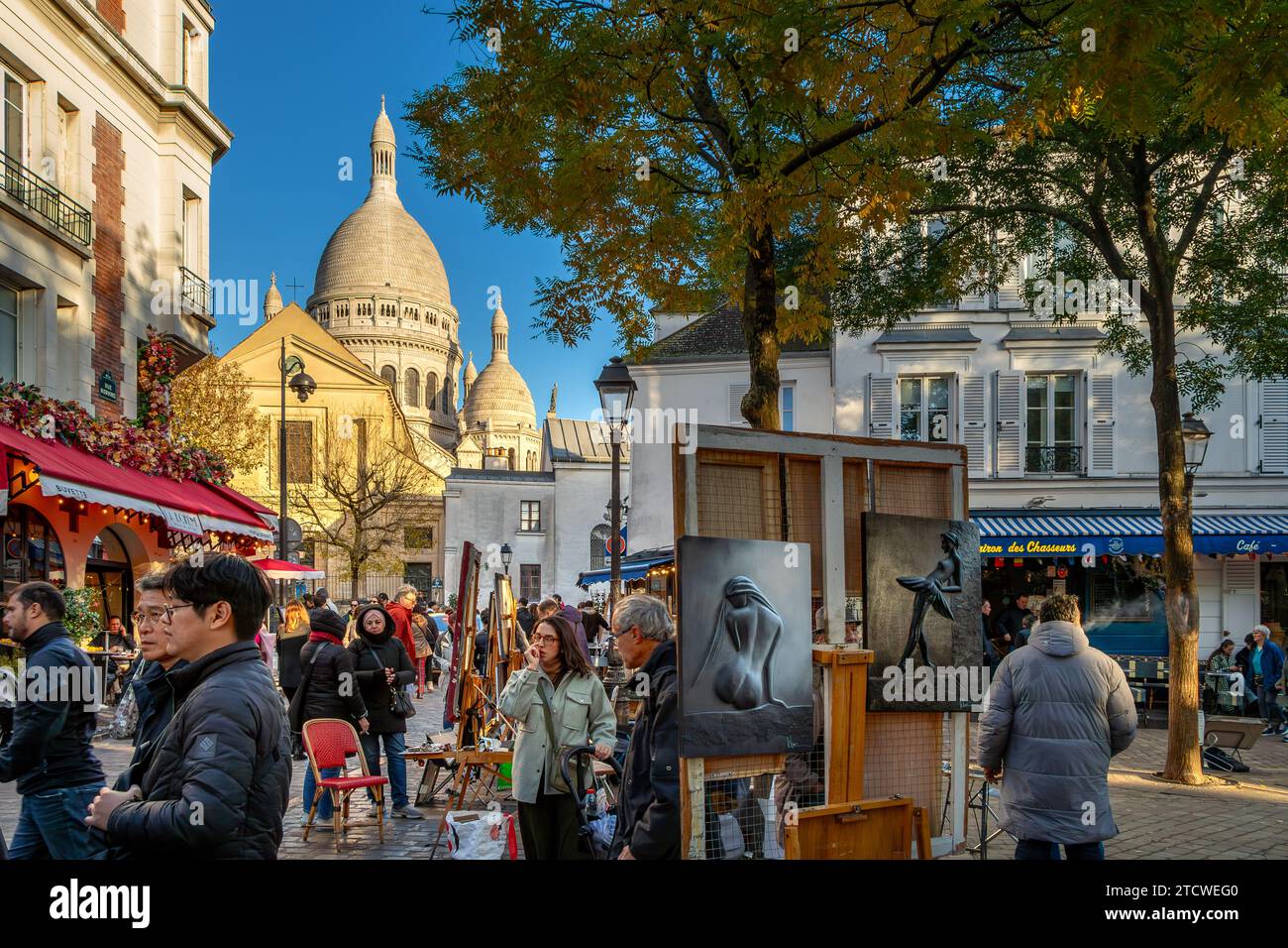 People walking around Place du Tertre looking at the artists and their work on a winters afternoon in Montmartre ,Paris, France Stock Photo