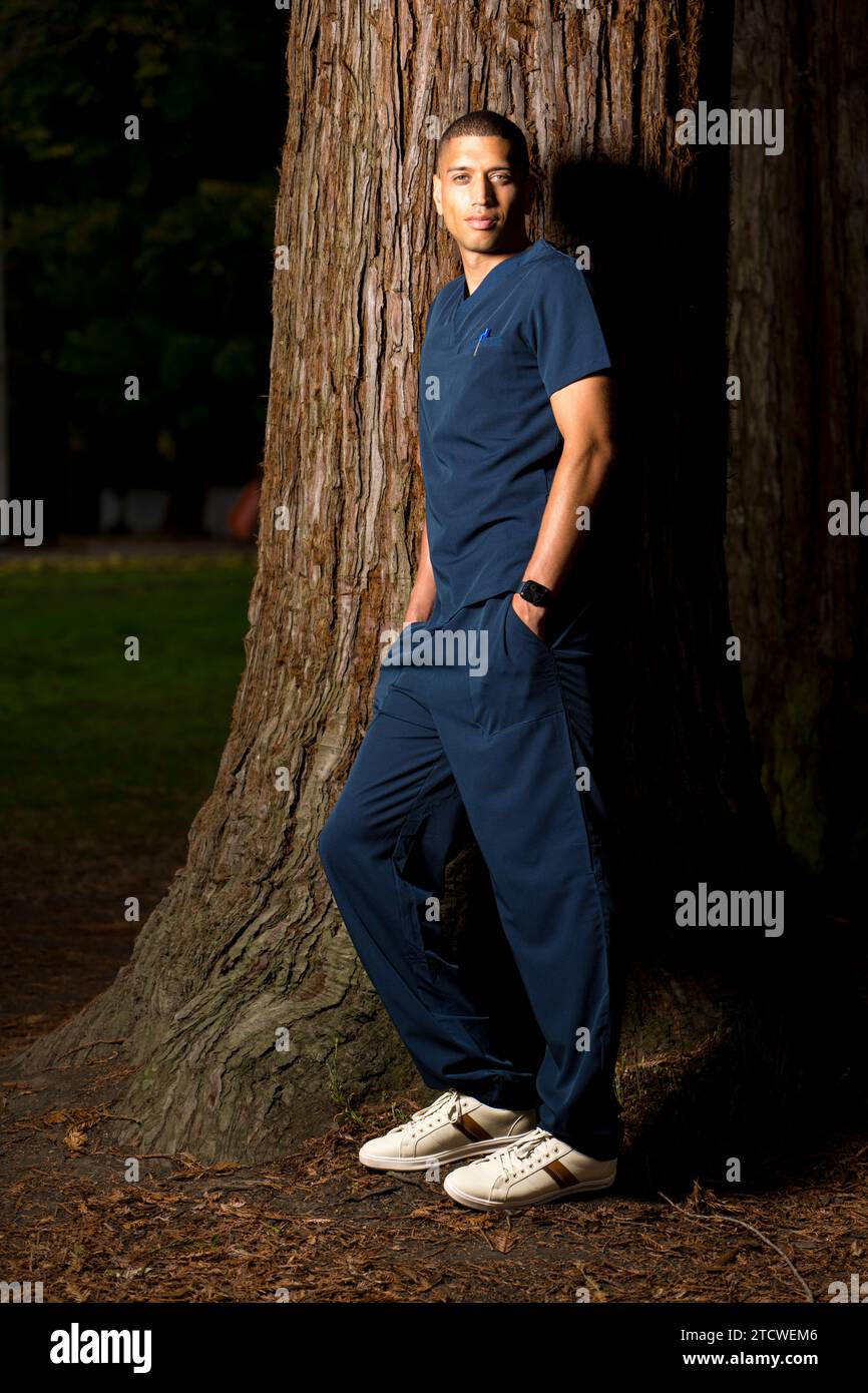 Medical Doctor Wearing Scrubs in a Park Late Afternoon Moody Stock