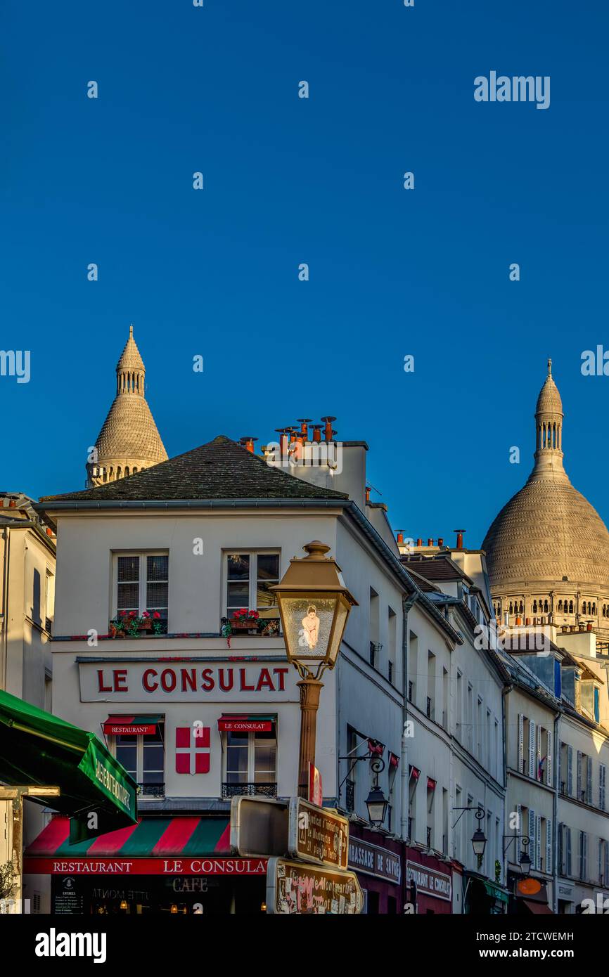 Le Consulat a restaurant in Monmartre, with the Sacré Coeur in the background in the late winter afternoon sunshine ,Montmartre, Paris, France Stock Photo