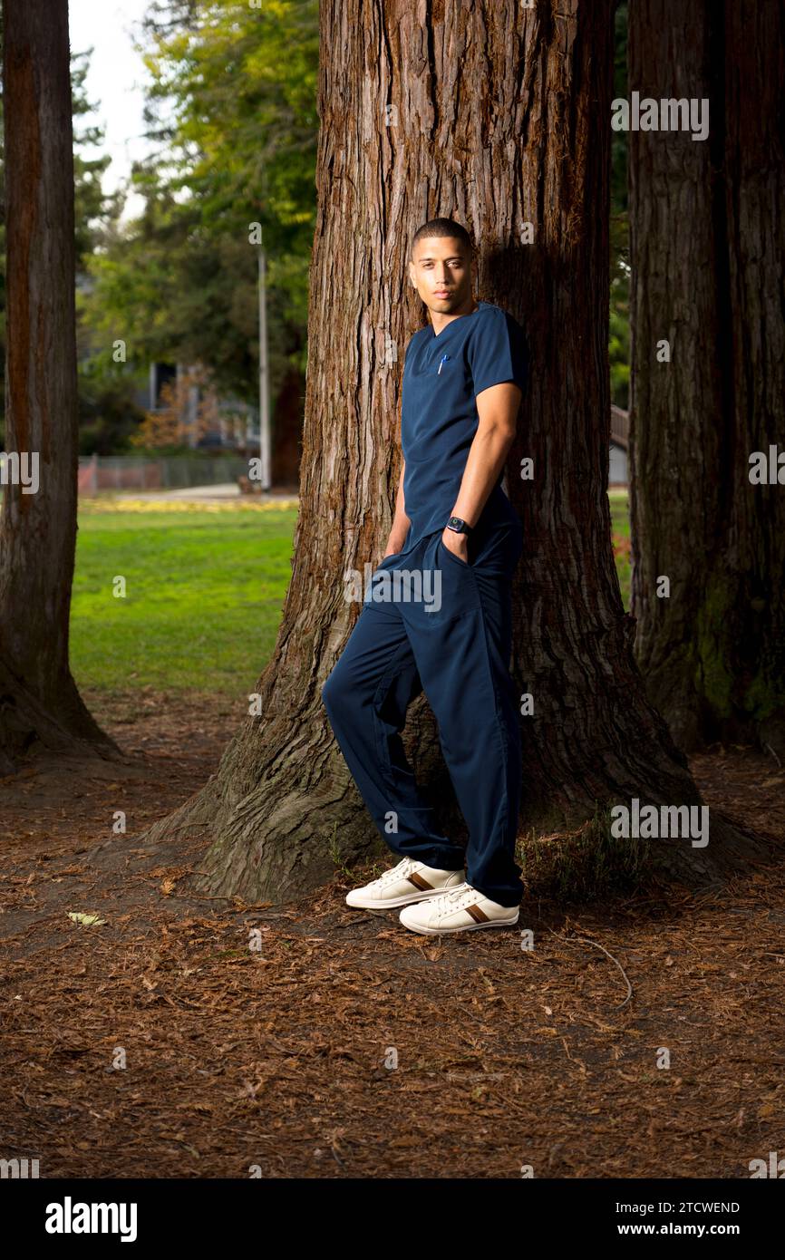 Medical Doctor Wearing Scrubs in a Park Late Afternoon Moody Stock